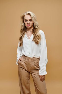 confident blonde woman trendy clothes posing with hand in pocket on beige, old money style fashion clipart