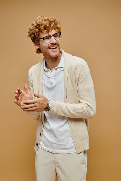 счастливый рыжий мужчина в старом костюме в стиле денег смотрит в сторону и смеется на бежевом фоне