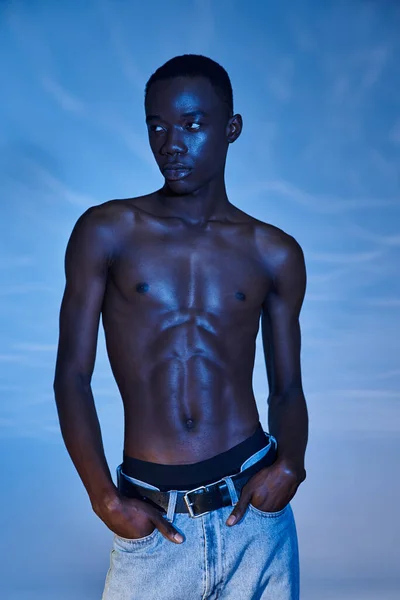 Mladý Africký Američan Muž Módní Džíny Pózování Modré Vodnaté Pozadí — Stock fotografie