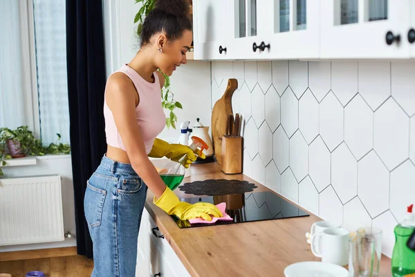 春のクリーニング中にラグを使用してストーブを洗浄カジュアルな服装でアフリカ系アメリカ人女性を魅了 — ストック写真