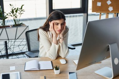 Modern bir ofiste çalışan bir iş kadını, bilgisayar ekranına odaklanmış, franchising kavramlarına dalmış..