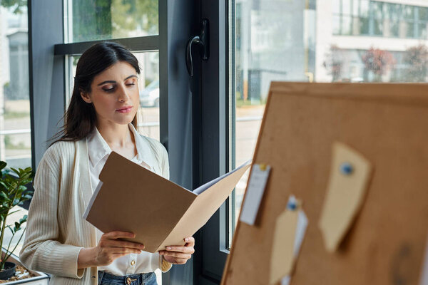 A focused businesswoman examines a piece of paper in a modern office, deep in thought about a franchise concept.
