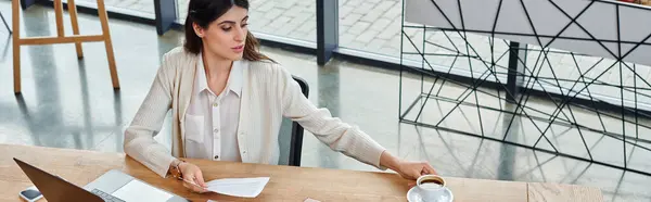 在现代办公环境中 一位女商人专心致志地工作 带着笔记本电脑坐在桌旁 — 图库照片
