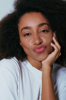 Çok güzel bir Afro-Amerikan kadının portresi. Patlak dudaklı kameraya bakıyor. Moda anlayışı.