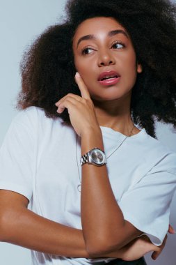Zarif giyinen, kıvırcık saçlı, şık görünümlü Afro-Amerikan moda belirleyicisi.