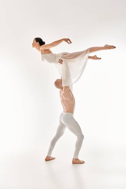 A shirtless young man and a woman in a white dress gracefully dance together, incorporating acrobatic elements, against a white studio backdrop. clipart