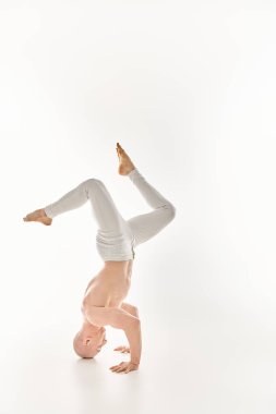 A man demonstrates strength and flexibility by performing a headstand. clipart