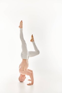A man balance in headstands while doing acrobatic exercises. clipart