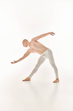 Genç bir adam akrobatik dans hareketleri sergiliyor. Beyaz arka planda bir stüdyoda titizlikle ve akışkanlıkla..