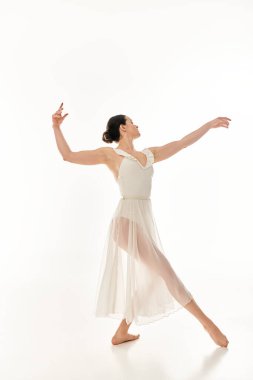 A young woman in a long, flowing white dress gracefully dances in a studio setting against a white background. clipart