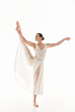 A young woman gracefully dances in a long white dress against a white background in a studio setting. clipart