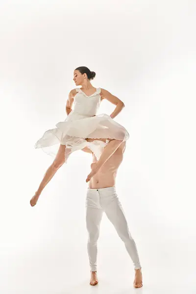 一个赤身裸体的男人和一个穿着白衣的女人一起跳舞 在一个背景为白色的工作室里表演杂技元素 — 图库照片