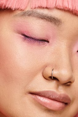 Mükemmel ciltli, pembe makyajlı ve burun piercingli güzel bir genç kadın.