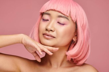 20 'li yaşlarda çekici Asyalı bir kadın. Gözleri kapalı, elleri çenesine dokunuyor.