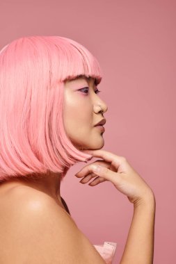 Pembe saçlı ve burnuna piercing takan sevimli Asyalı kadın profili canlı arka planda çeneye dokunuyor