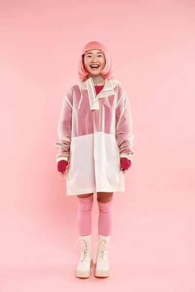 快乐而漂亮的亚洲女人 粉红的头发 穿着雨衣 在充满活力的背景下摆姿势 — 图库照片