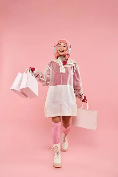 Pembe Saçlı Kulaklıklı Alışveriş Çantalı Mutlu Asyalı Kız — Stok fotoğraf