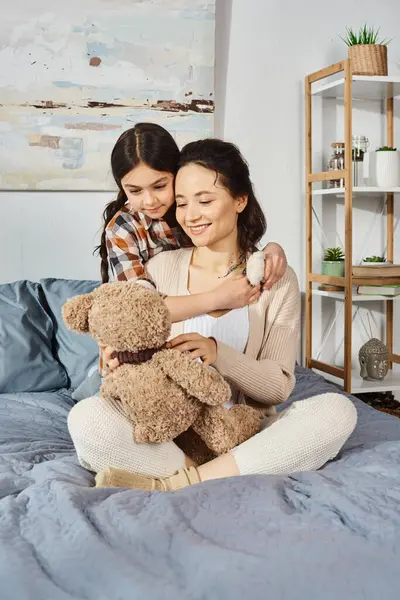 一对母女坐在床上 抱着一只泰迪熊 热情地拥抱在一起 享受着美好的时光 — 图库照片
