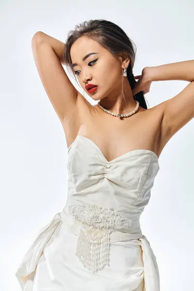 Gelinlik Giymiş Çekici Asyalı Genç Kadın Aşağıya Bakıyor Ellerini Başının — Stok fotoğraf