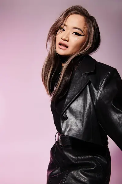 stock image charming asian young girl in black leather outfit with heavy makeup standing sideways