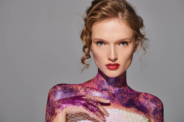 A young woman exudes classic beauty as her body is painted in shades of purple and white, striking a pose in a studio setting.
