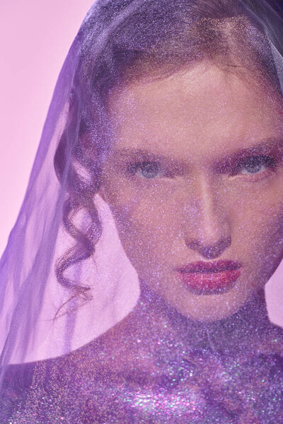 Молодая женщина излучает классическую красоту в студии, надев вуаль на голову, излучающую элегантность и изящество.