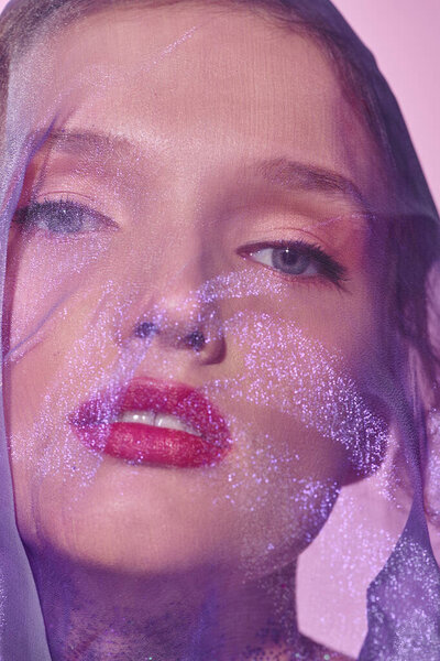 Молодая женщина излучает классическую красоту, позируя в студии, с вуалью на голове.