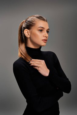 A young, beautiful woman with long hair stands confidently in a black turtleneck sweater, exuding elegance and grace. clipart