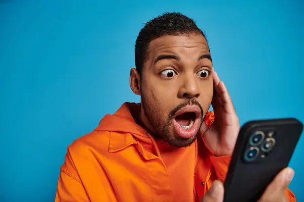 Shocked African American Man Scrolling Social Media Smartphone Blue Background — Stock Photo, Image