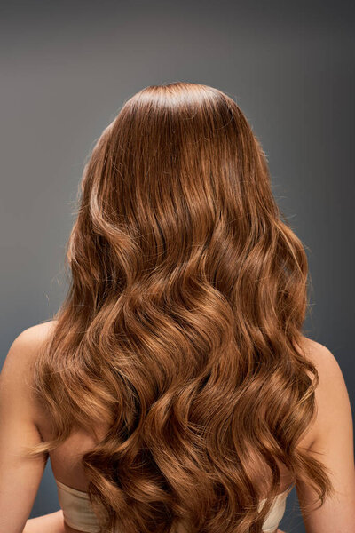 Затылок женщины с красивыми, длинными, волнистыми волосами каскадом вниз без особых усилий.