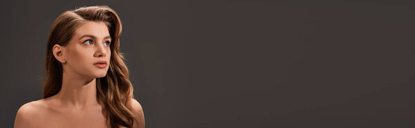 A young woman with long brown wavy hair gazes upward in a moment of introspection and contemplation.