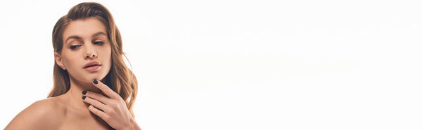 Молодая женщина с длинными волнистыми волосами нежно касается плеч.