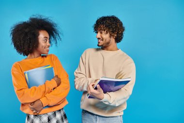 İki ırklar arası öğrenci, birlik ve çeşitliliği simgeleyen mavi bir zeminde yan yana dururlar..