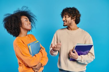 İki ırklar arası öğrenci, bir stüdyo ortamında mavi bir arkaplanda, birlik ve çeşitlilik sergiliyorlar..