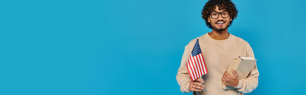 Мужчина в повседневной одежде держит планшет с американским флагом на заднем плане, показывая патриотизм и организацию.