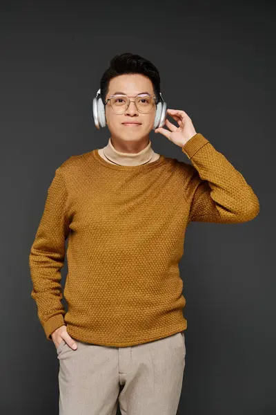 Modny Młody Człowiek Przytulnym Swetrze Słucha Uważnie Przez Eleganckie Słuchawki — Zdjęcie stockowe