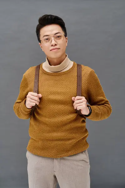 Modny Młodzieniec Pewnością Pozuje Brązowym Swetrze Emanując Elegancją Stylem — Zdjęcie stockowe