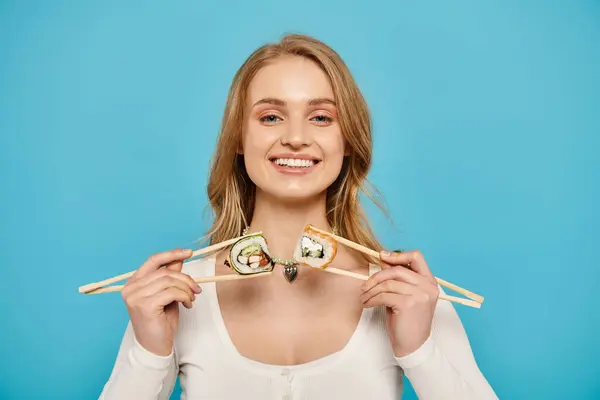 Blonde Woman Delicately Holds Two Chopsticks Sushi Perched Them Showcasing — Stock Photo, Image