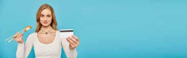 Uma Mulher Bonita Com Cabelo Loiro Tem Cartão Crédito Pauzinhos — Fotografia de Stock