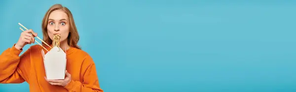 Stylowa Blondynka Trzyma Pudełko Azjatyckiego Jedzenia Podczas Balansowania Pałeczki Ustach — Zdjęcie stockowe