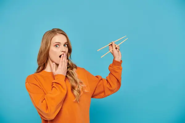 Stylish Woman Orange Sweater Gracefully Holds Pair Chopsticks Ready Enjoy — Stock Photo, Image