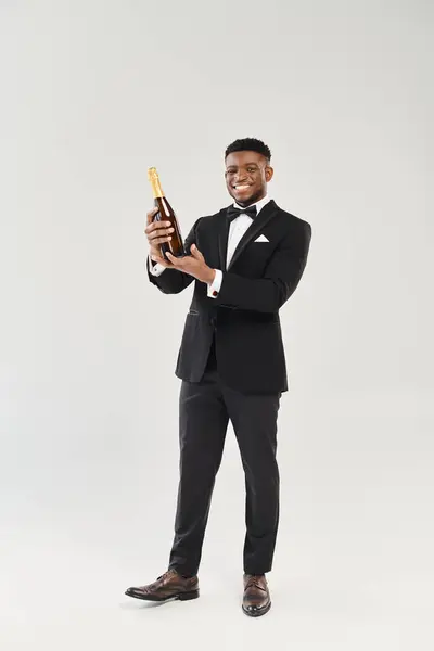 穿着燕尾服的英俊的非洲裔美国新郎拿着香槟酒瓶 准备举杯庆祝 — 图库照片