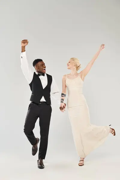 stock image A man and woman in formal wear gracefully dance together, showcasing elegance and sophistication.