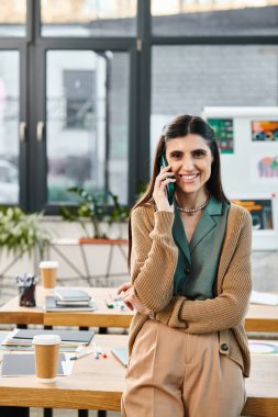 Cep telefonuyla konuşan bir kadın masada oturuyor..