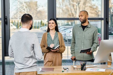 Çeşitli profesyonellerden oluşan bir grup, bir iş projesi hakkında fikir alışverişinde bulunmak ve fikir üretmek için masanın etrafında toplandı..