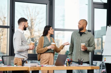 A diverse group of professionals gather around a table, discussing ideas and working on a project in a modern office setting. clipart