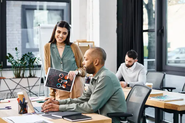 Bir erkek ve bir kadın, projelerine dalmış şık bir ofis masasında odaklanmış bir tartışmaya girişiyor..