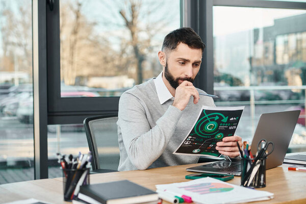 Человек сидит за столом, глубоко погруженный в диаграммы, погруженный в учебу и размышления.