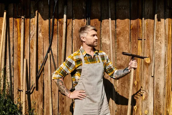 Köyde samanla uğraşırken yaba kullanarak kendini adamış yakışıklı bir çiftçi.