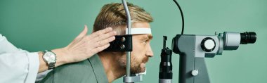 Devoted doctor examines mans eyes through a microscope in a doctors office for laser vision correction. clipart